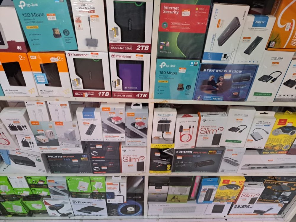 Wall of accessories in stock at SATT Computers — external hard drives, USB adapters and HDMI splitters
